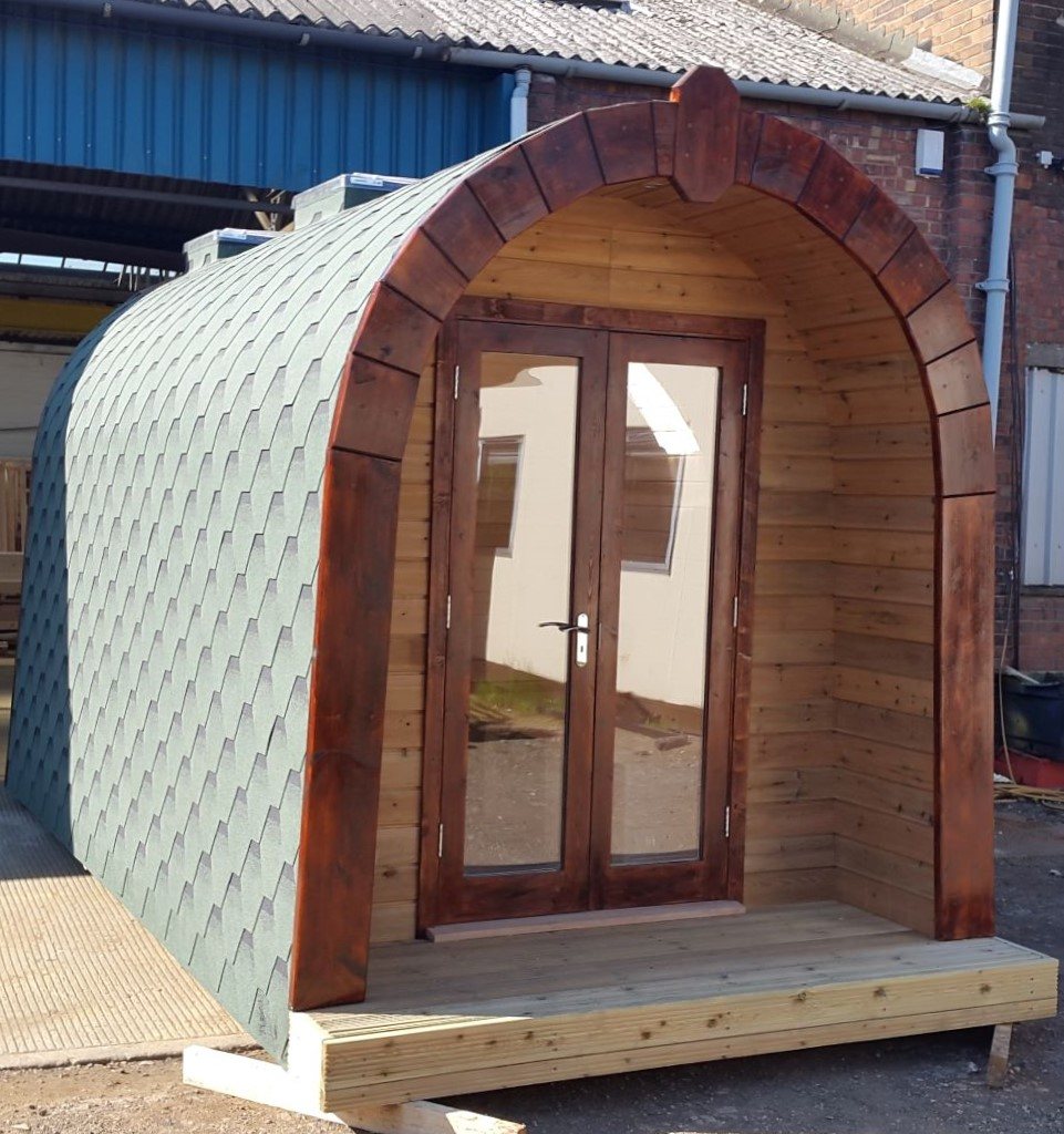 Curved timber glamping pod with glazed doors
